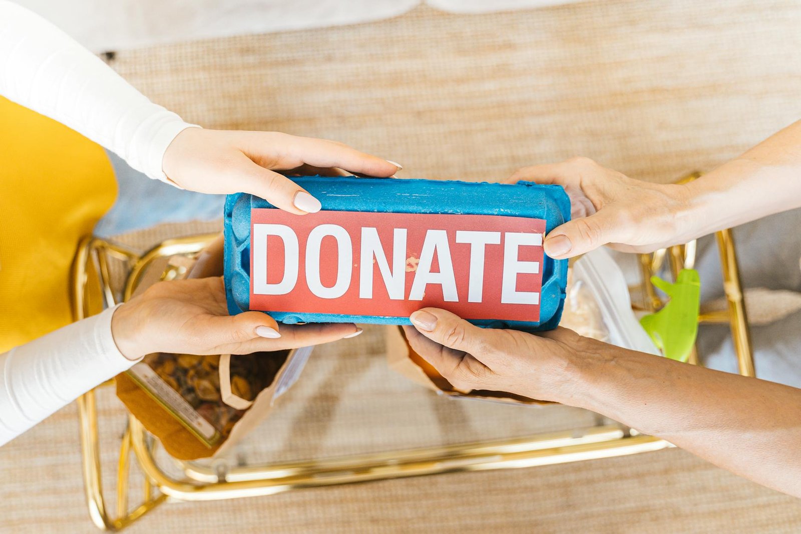 Hands exchanging a donation box symbolising generosity